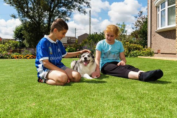 Kids Sitting on Fake Grass with Their Dog (foto)