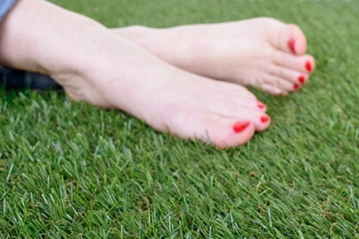 touching fake grass with feets (photo)